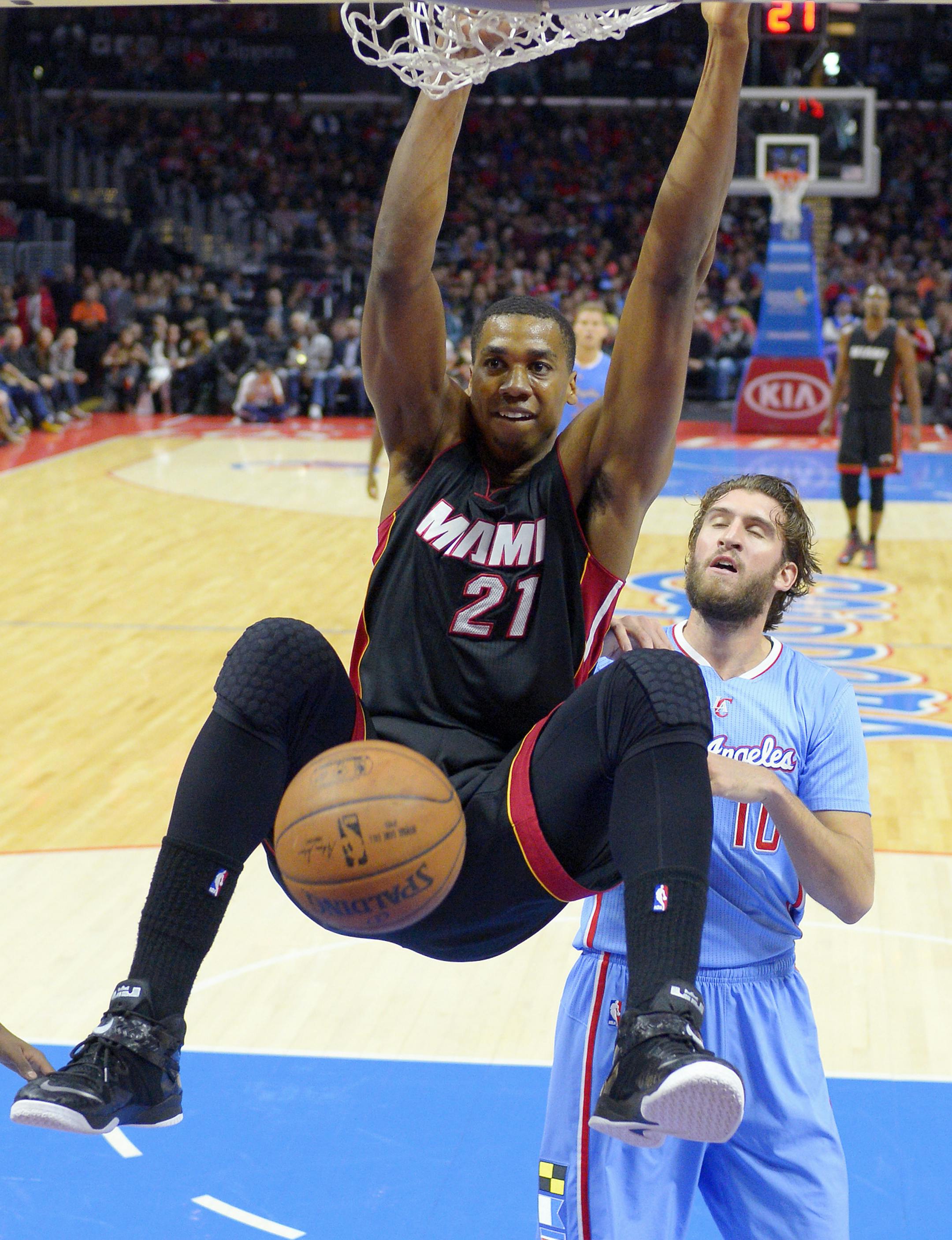 Miami Heat center Hassan Whiteside, left, dunks as Los Angeles Clippers forward Spencer Hawes defends during the first half of an NBA basketball game, Sunday, Jan. 11, 2015, in Los Angeles. (AP Photo/Mark J. Terrill) ORG XMIT: LAS109