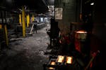 A worker sweeps up silica sand around casting molds at Smith Foundry Tuesday, Dec. 12, 2023 Minneapolis, Minn. For years, residents have been complain