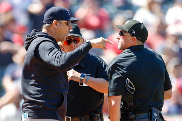 Aaron Boone, left, of the New York Yankees argues a review call with home plate umpires Chris Guccione, right, and Larry Vanover, after being ejected 