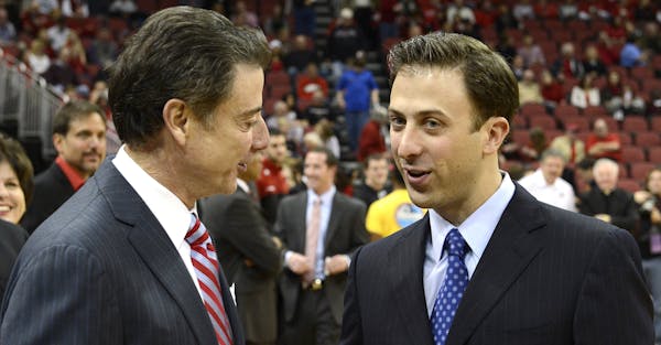 Louisville coach Rick Pitino, left, shakes hands with his son Richard Pitino, right, coach of Florida International, before their NCAA college basketb