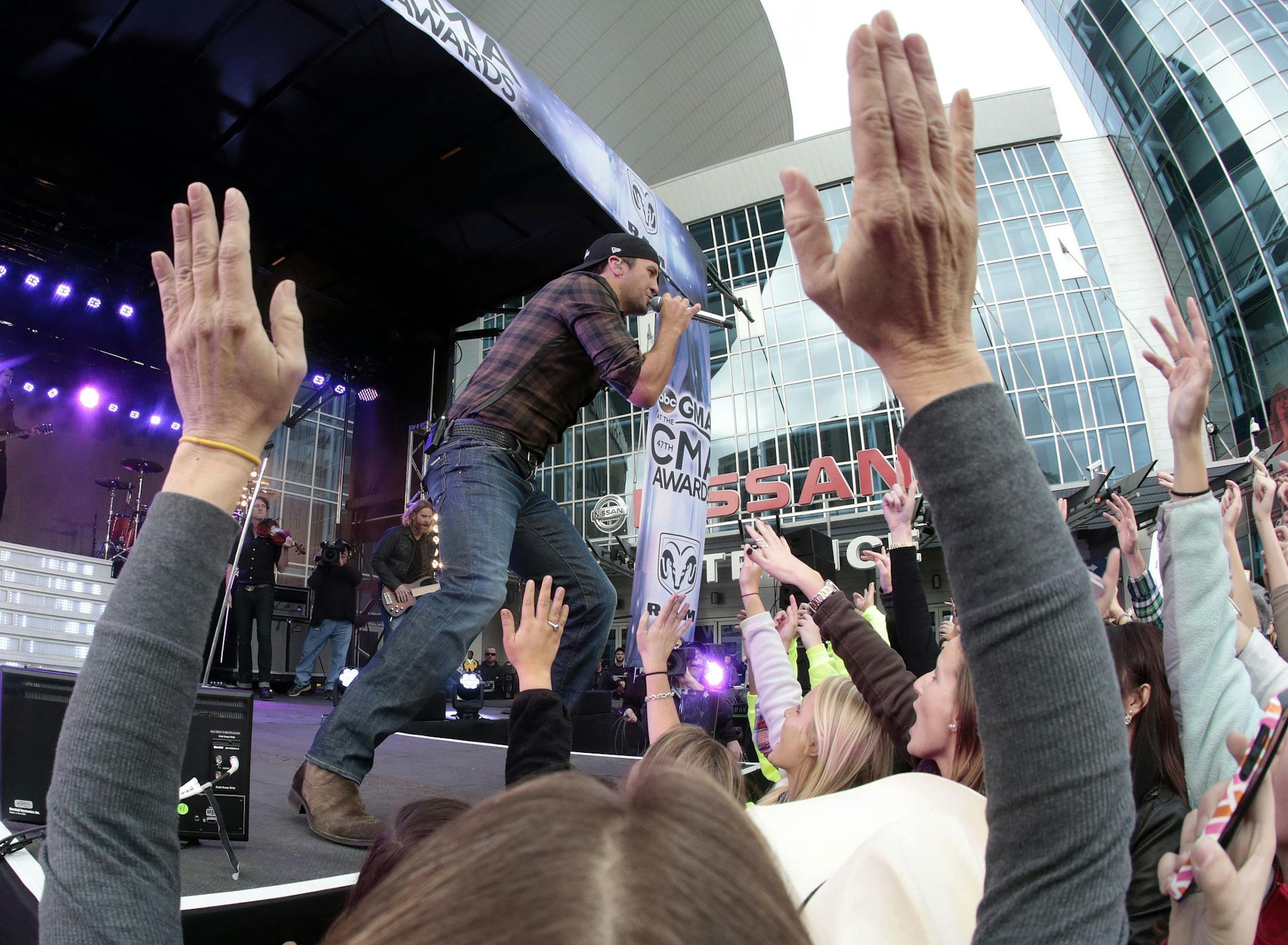 Fans cheer as Luke Bryan performs outside of Bridgestone Arena on Wednesday, Nov. 6, 2013, in Nashville, Tenn. The Country Music Association Awards will be held at the venue Wednesday night. (AP Photo/Mark Humphrey)