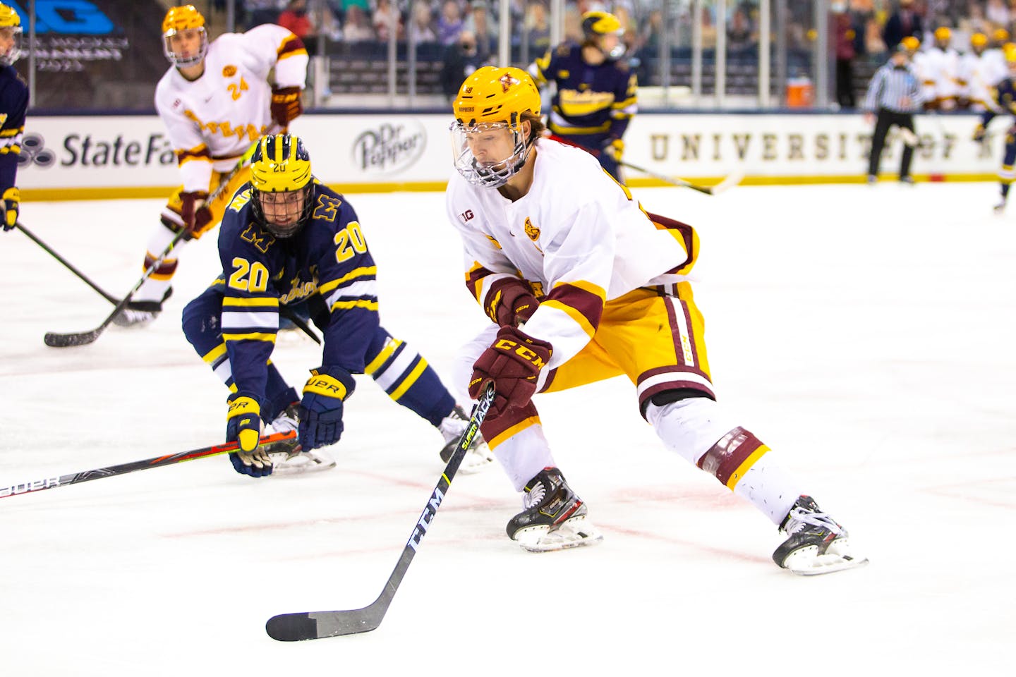 Minnesota Gophers forward Sampo Ranta controls the puck near Michigan defenseman Keaton Pehrson during the Big Ten Men's Ice Hockey Tournament Semi-Final action between University of Michigan vs University of Minnesota at Compton Family Ice Arena in South Bend, Indiana on March 15, 2021