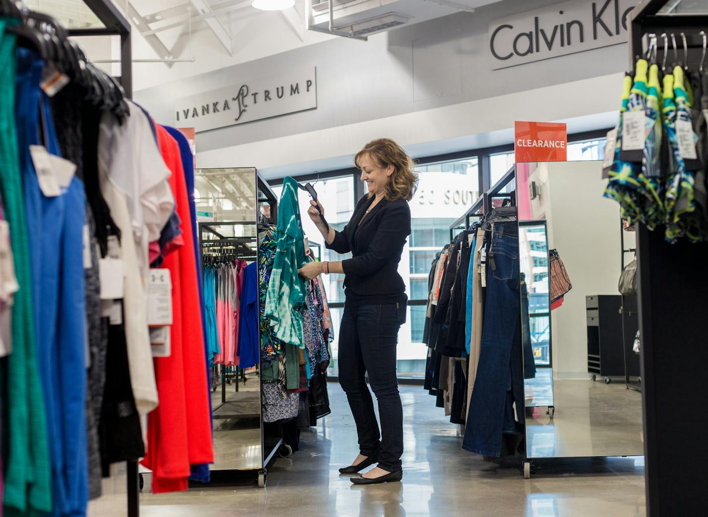 An employee straightens up clothing to prepare for the grand opening. ] Elizabeth Brumley special to the Star Tribune * Saks Off Fifth re-opens in downtown Minneapolis City Center after closing early last year in Gaviidae Common.