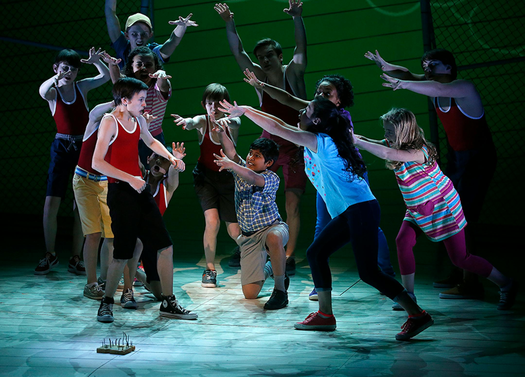 left, Greg, played by Ricky Falbo, with the cast during the playground scene with the moldy cheese found on the ground, in the Diary of a Wimpy Kid the Musical.