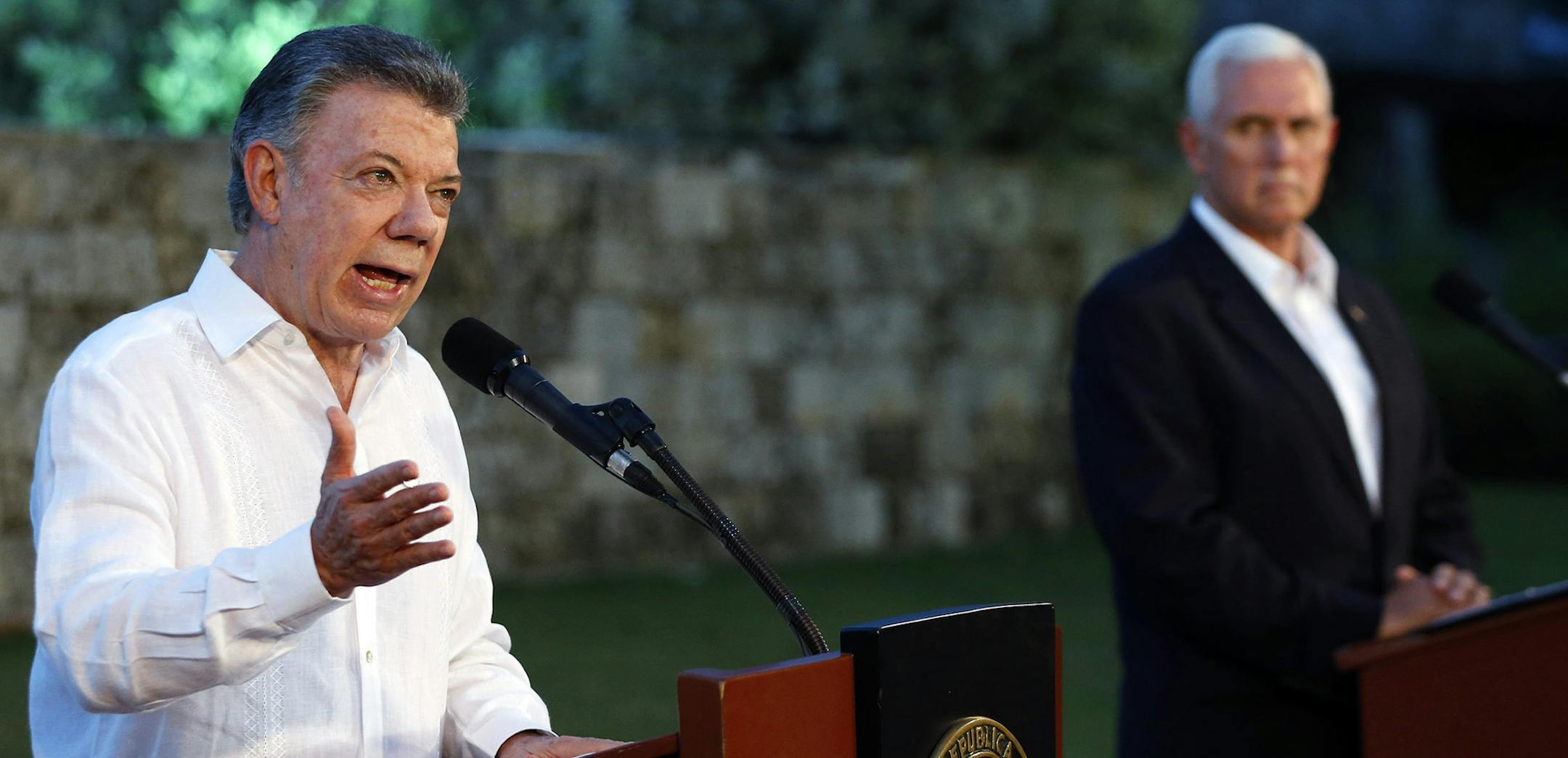 Colombian President Juan Manuel Santos, left, spoke to the media as U.S. Vice President Mike Pence listened during a joint news conference in Cartagena, Colombia, on Sunday. One topic was turmoil in neighboring Venezuela. Santos said the possibility of military intervention there “shouldn’t even be considered.”