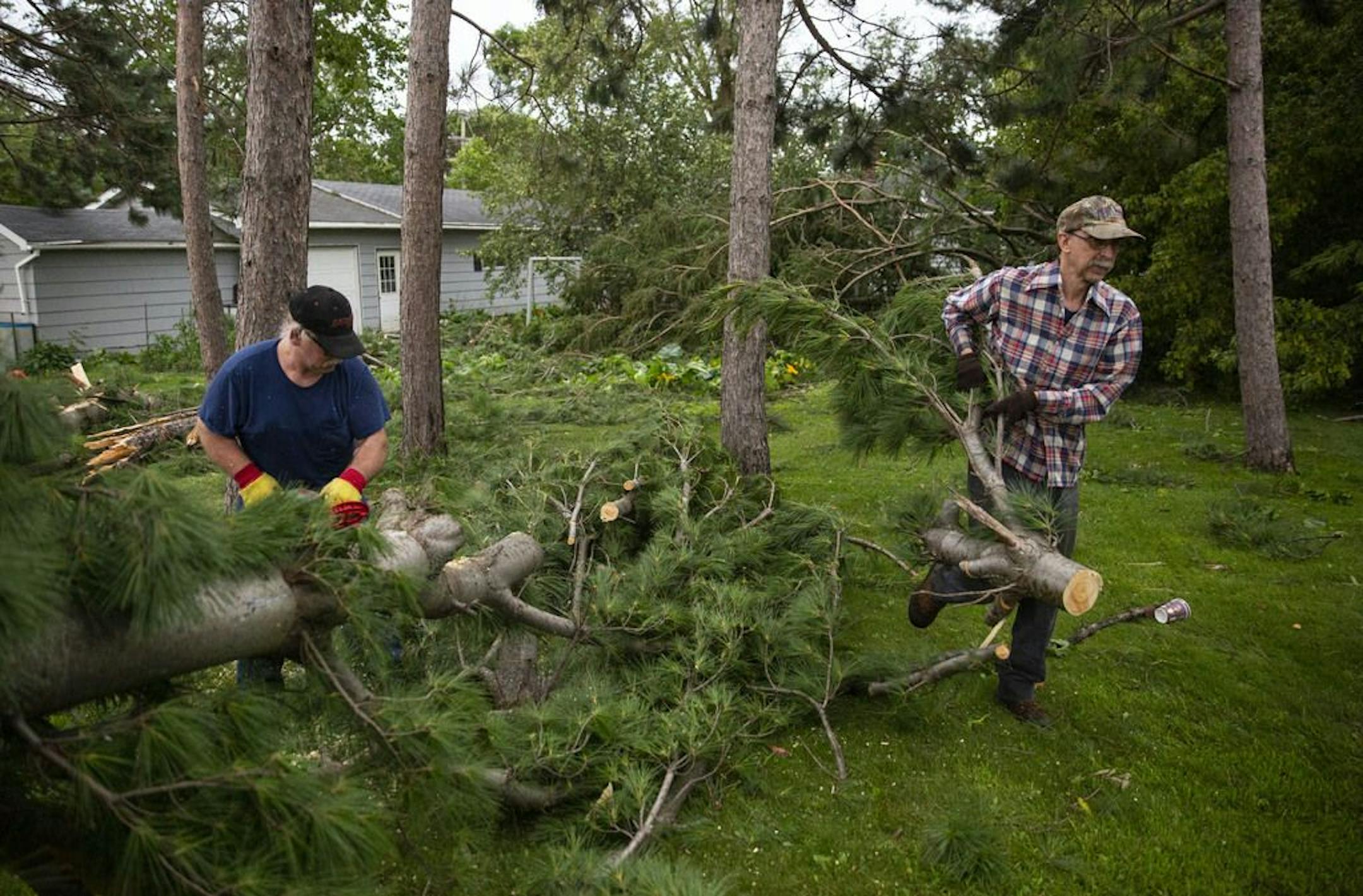 Roger, left, and Wendell Hatalla cut up and removed debris left from the storm Saturday near Turtle Lake, Wis. Storms ripped through western Wisconsin on Friday evening, hitting towns like Turtle Lake especially hard.