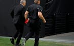 Las Vegas Raiders director of team security Bob Stiriti, left, and former Raiders head coach Jon Gruden run off the field after the team’s 20-9 loss