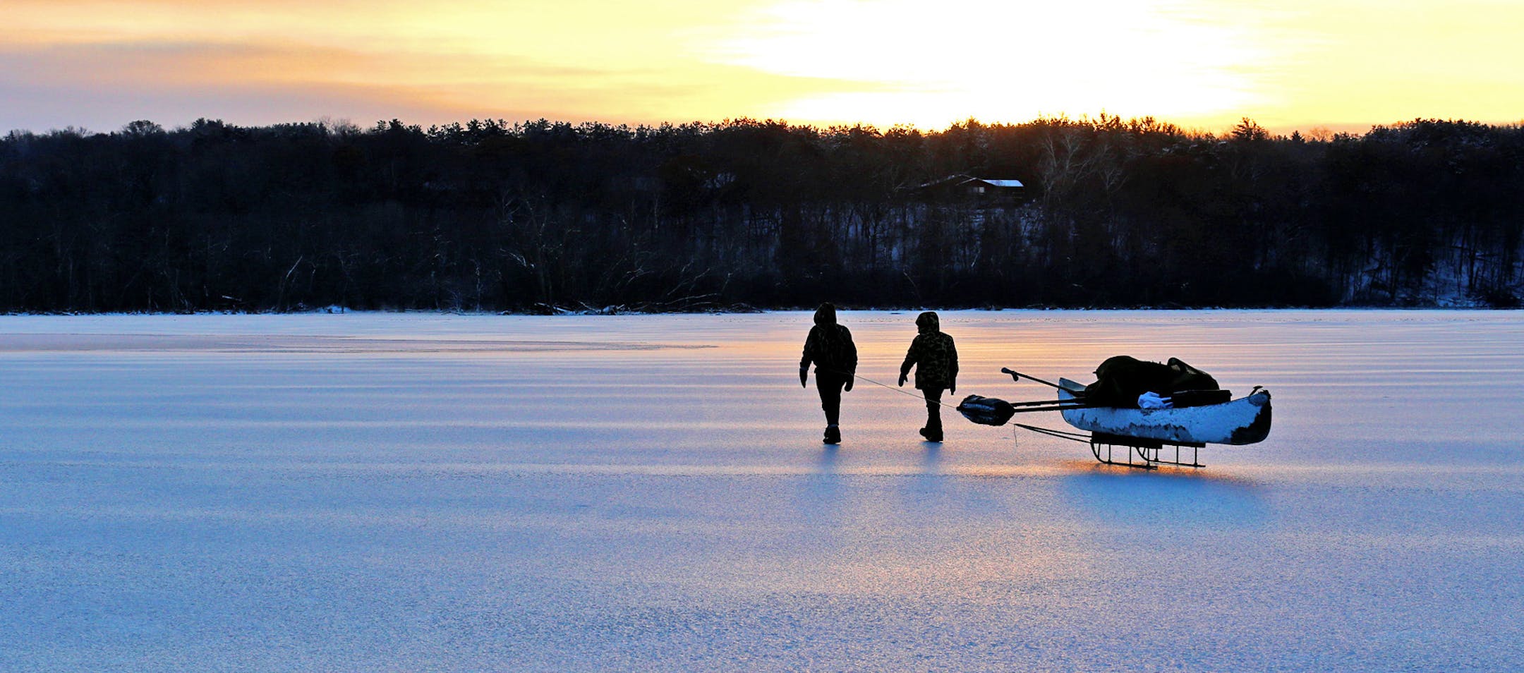 Wendell and Galina Diller pull their sled and canoe across ice on a goose hunt Friday morning. The canoe is used when weak ice is encounered. The craft's outrigger on its left side gives it stability, allowing hunters who break through the ice to crawl into the canoe. The Dillers wore waders and life jackets.
