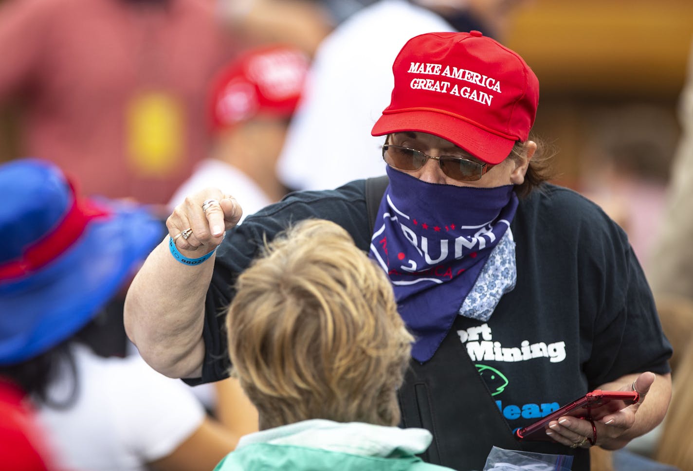 A woman donning a "Make America Great Again" hat talked to some fellow supporters as they waited for Vice President Mike Pence to arrive in Duluth on Friday.