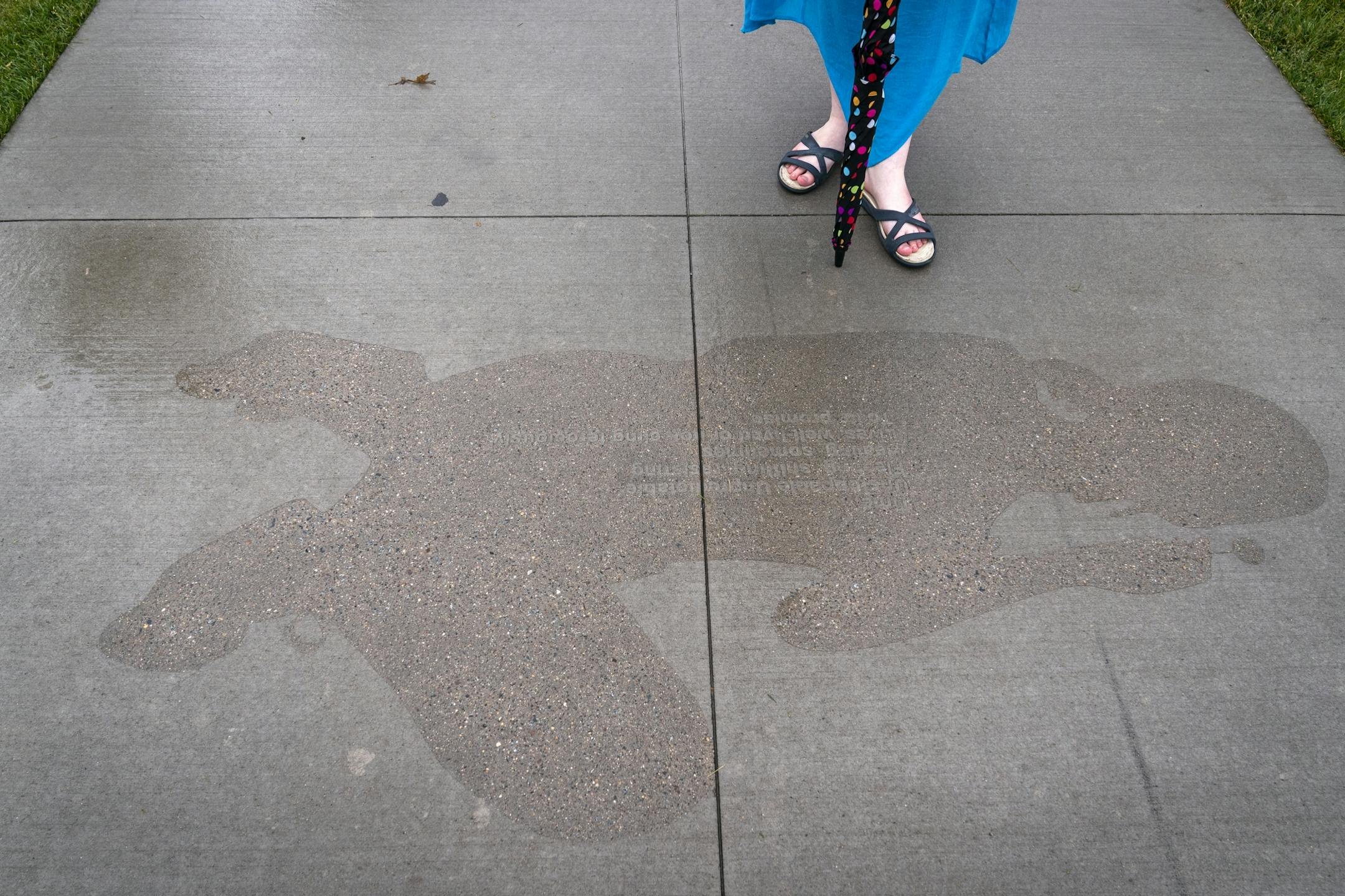 A person stands to look at "Time" from the series "Shadows at the Crossroads" during the public unveiling.
