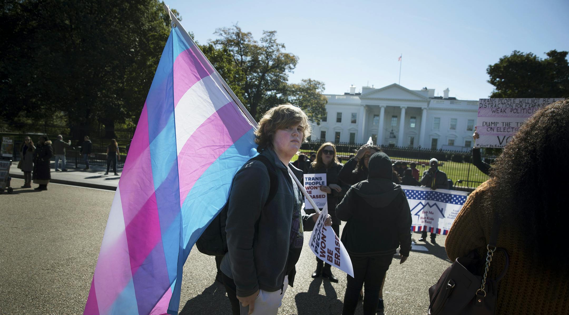 A protester carries a transgender flag outside of the White House in Washington, Oct. 22, 2018. Activists in the LGBT community mobilized a fast and fierce campaign on Monday to say transgender people cannot be expunged from society, in response to an unreleased Trump administration memo that proposes a strict definition of gender based on a personís genitalia at birth. (Sarah Silbiger/The New York Times)