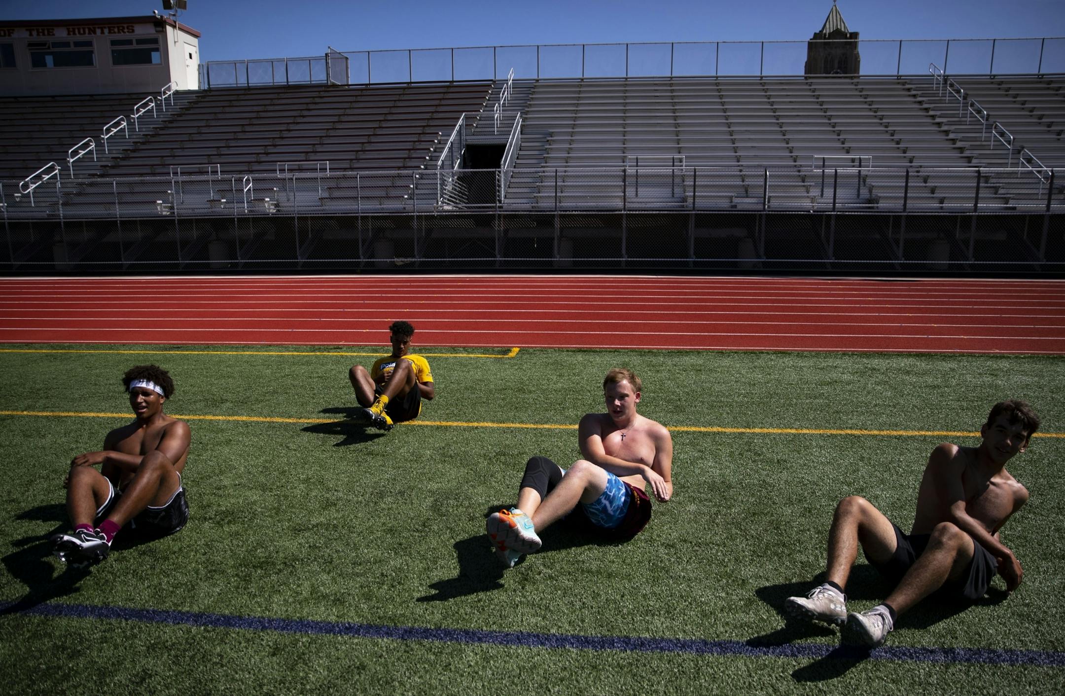 (Left) Denfeld High School players Jayden Hester, Keyshawn Beckom, Jacob Plunkett and CJ Christanson do ab workouts on Tuesday morning.