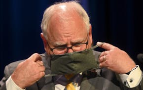 Minnesota Gov. Tim Walz put his face mask at the conclusion of a press conference Thursday, July 30, 2020 announcing the learning plan for Minnesota s