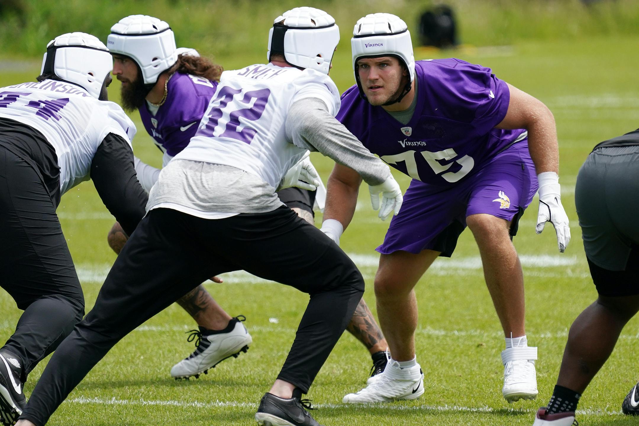 Minnesota Vikings offensive tackle Brian O'Neill (75) eyed linebacker Cameron Smith (32).