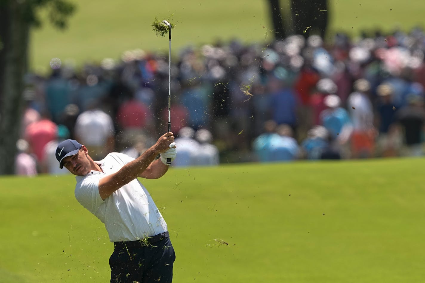 Brooks Koepka hits from the rough on the first hole during the first round of the PGA Championship at Southern Hills Country Club