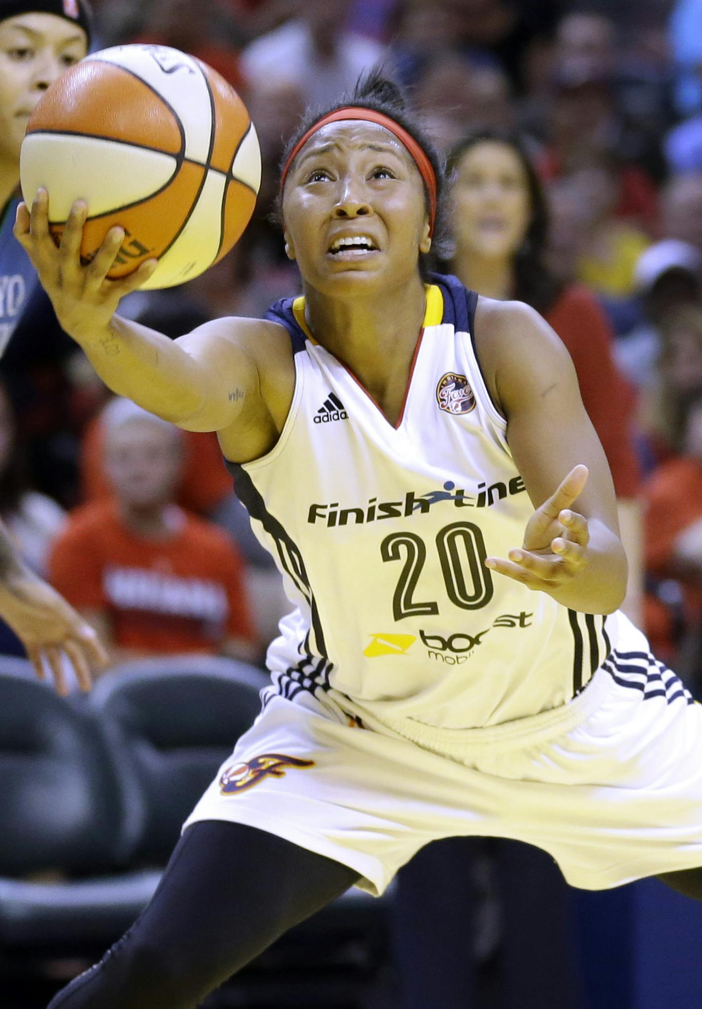 Indiana Fever's Briann January, center, heads to the basket as Minnesota Lynx's Seimone Augustus, left, and Anna Cruz, right, watch in the first half of Game 4 of the WNBA Finals basketball series, in Indianapolis, Sunday, Oct. 11, 2015. (AP Photo/Michael Conroy)