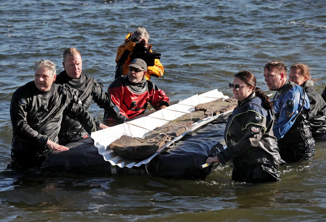 Archaeologists from the Wisconsin Historical Society float a recovered 3,000-year-old dugout canoe on Lake Mendota to Spring Harbor Beach in fall 2022.  