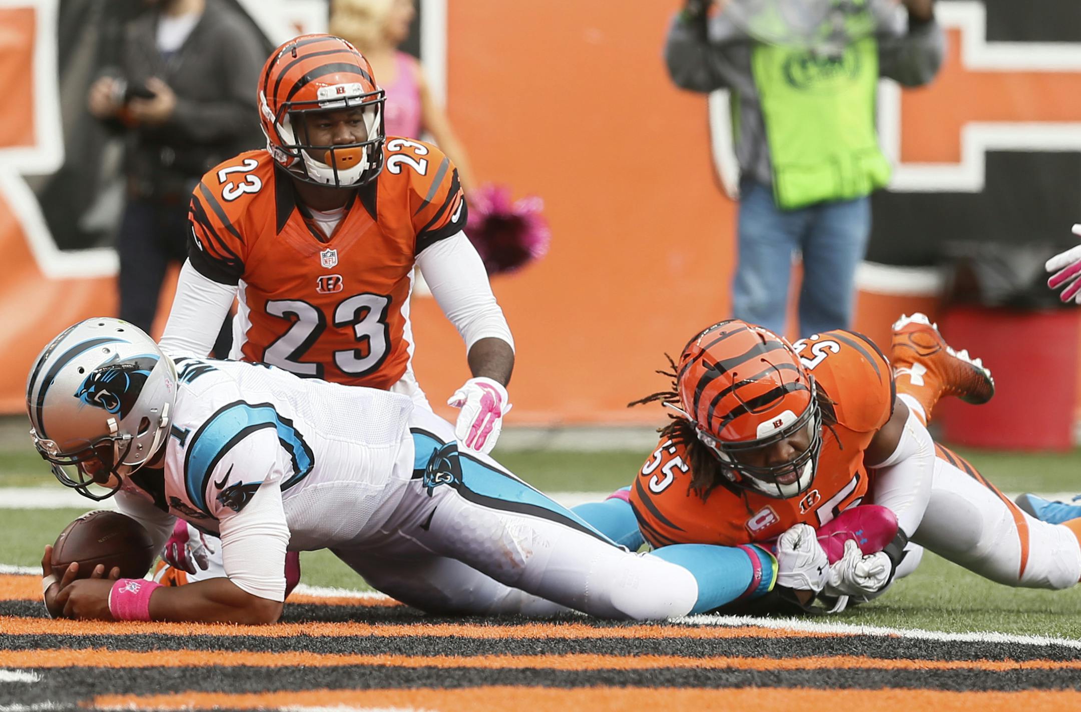 Carolina Panthers quarterback Cam Newton (1) runs through Cincinnati Bengals cornerback Terence Newman (23) and outside linebacker Vontaze Burfict (55) for a 12-yard touchdown in the second half of an NFL football game, Sunday, Oct. 12, 2014, in Cincinnati. (AP Photo/Paul Sancya) ORG XMIT: PBS101