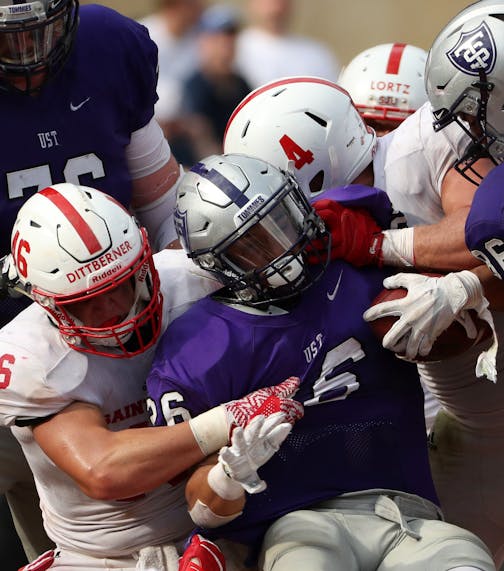 University of St. Thomas running back Josh Parks (26) was pulled down by St. John's University defensive lineman Trevor Dittberner (46) in the second half. ] ANTHONY SOUFFLE • anthony.souffle@startribune.com Game action from an NCAA football game between the University of St. Thomas and St. John's University Saturday, Sept. 23, 2017 at Target Field in Minneapolis. ORG XMIT: MIN1709231707130197