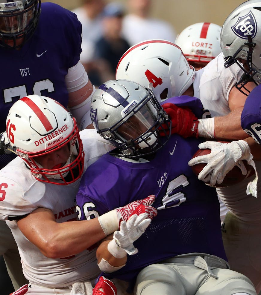 University of St. Thomas running back Josh Parks (26) was pulled down by St. John's University defensive lineman Trevor Dittberner (46) in the second half. ] ANTHONY SOUFFLE • anthony.souffle@startribune.com Game action from an NCAA football game between the University of St. Thomas and St. John's University Saturday, Sept. 23, 2017 at Target Field in Minneapolis. ORG XMIT: MIN1709231707130197