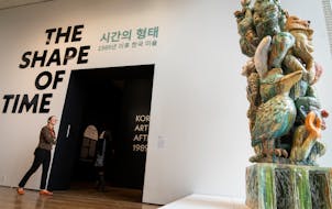 People enter the gallery, walking past “Monument for Parents” by Sunkoo Yuh, at the entrance to “The Shape of Time: Korean Art after 1989” at 
