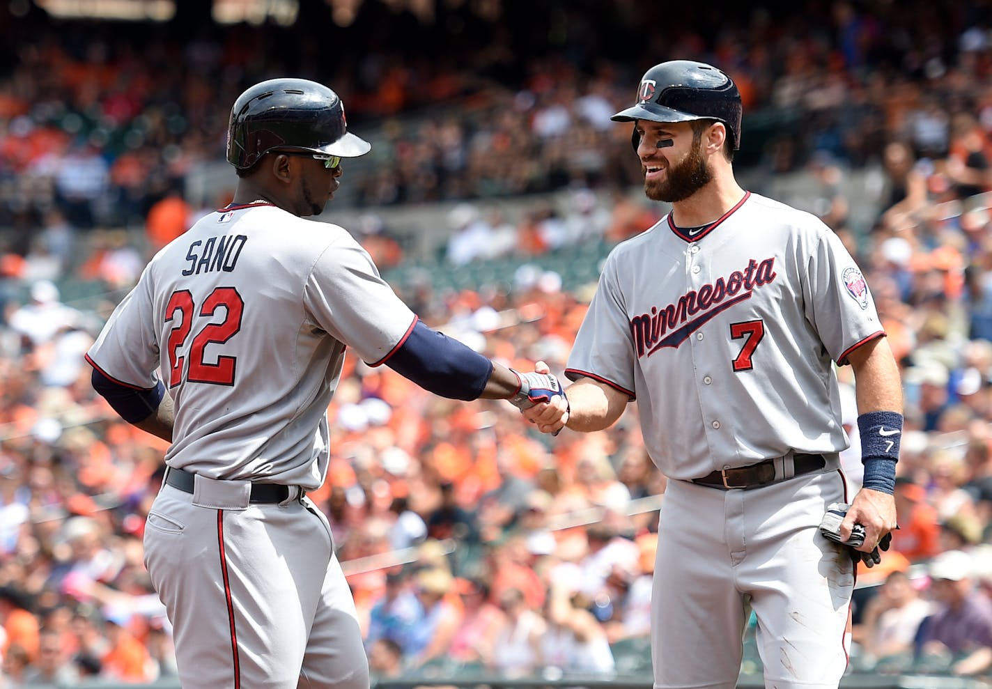 Minnesota Twins' Miguel Sano (22) is greeted by Joe Mauer (7) at home after Sano hit a two-run home run against the Baltimore Orioles during the first inning of a baseball game, Sunday, Aug. 23, 2015, in Baltimore. (AP Photo/Nick Wass)