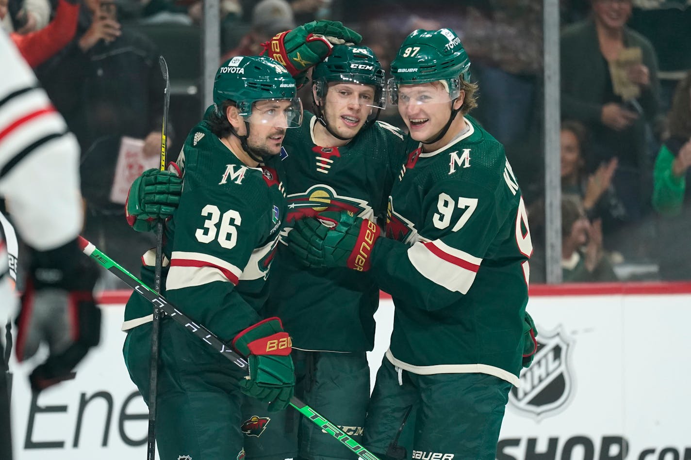 Minnesota Wild center Marco Rossi (23), center, celebrates with right wing Mats Zuccarello (36), left, and left wing Kirill Kaprizov (97), right, after scoring a goal against the Chicago Blackhawks during the first period of an NHL preseason hockey game Thursday, Oct. 6, 2022, in St. Paul. (AP Photo/Abbie Parr)