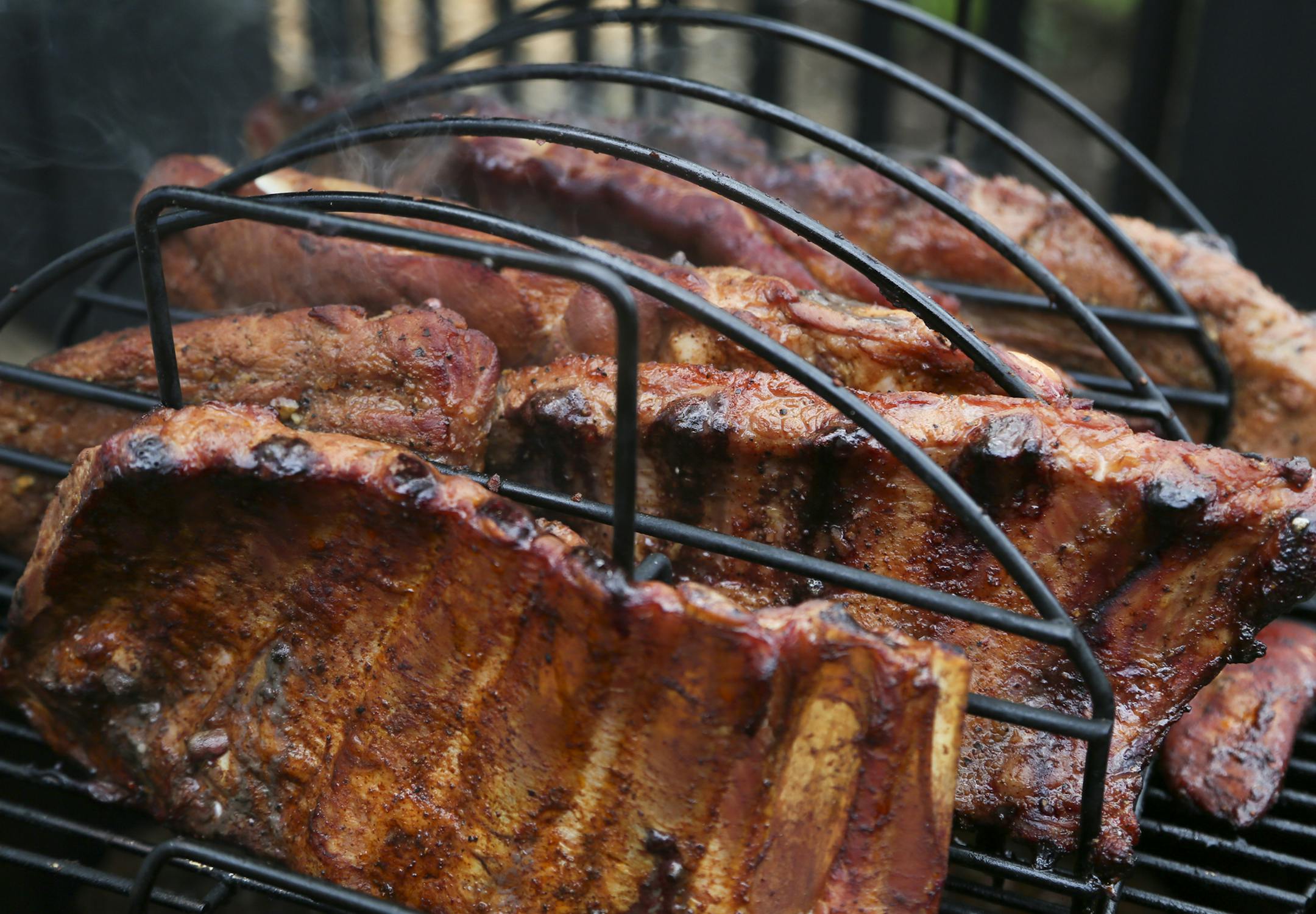 Spare ribs are slowly smoked on a grill during Smokapalooza 2013, on the deck of the Pupel family residence Saturday, May 26, 2013 in Plymouth, MN.](DAVID JOLES/STARTRIBUNE) djoles@startribune How do you learn the intricacies and nuances of user a smoker? By having lots and lots of experiments going on at one time. How do you do that? By gathering 10 families, smokers and grills at the ready, for Smokapalooza. Everyone learns, by successes and failures, and they eat really well. More than 200 po