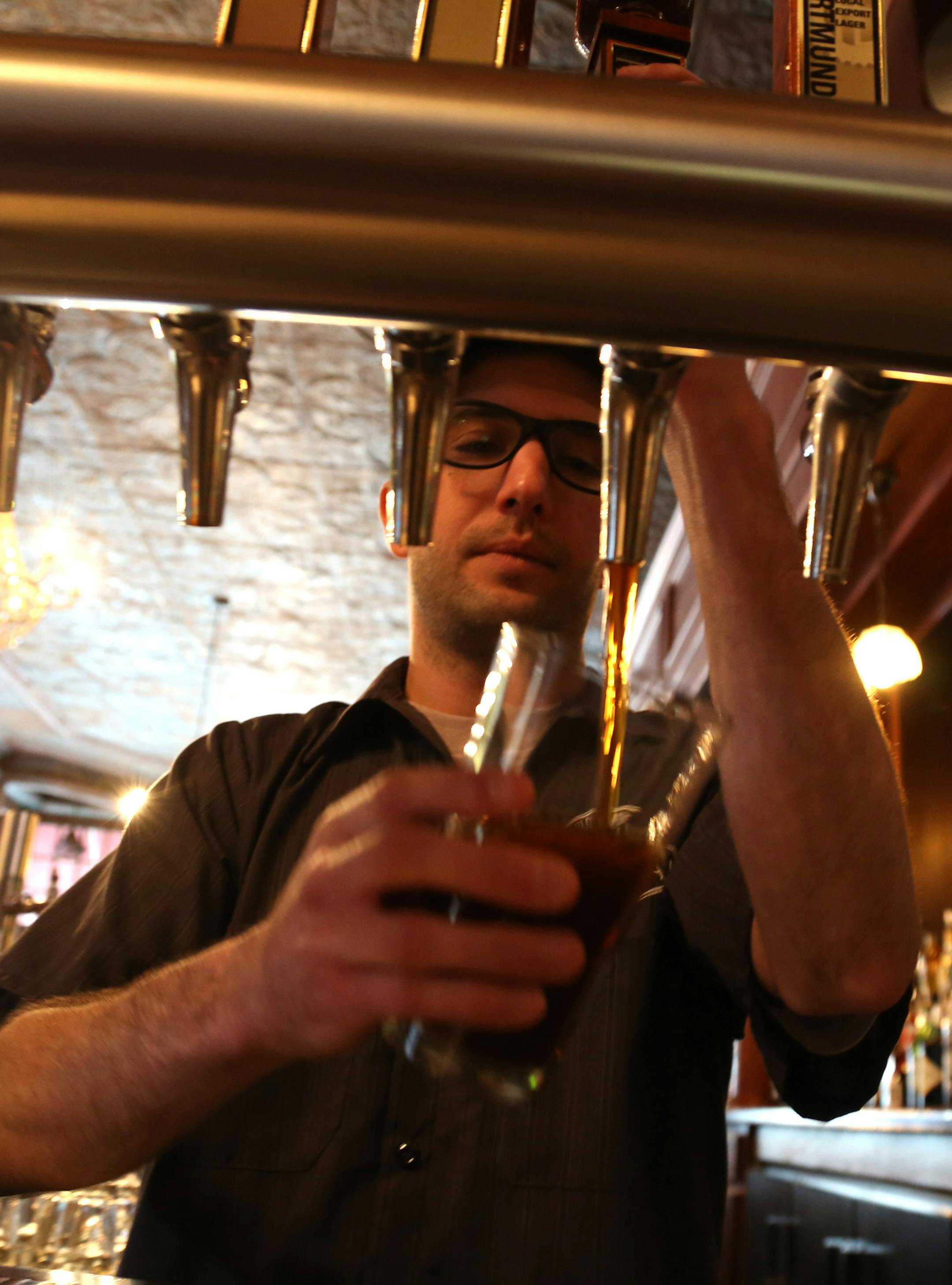 Chris O'Connor pours a house scotch ale at the reopened Town Hall Brewery. ] (KYNDELL HARKNESS/STAR TRIBUNE) kyndell.harkness@startribune.com The beginning of Barrel- Aged Beer Week and the reopening of Town Hall Brewery in Minneapolis Min, Saturday, April 5, 2014.
