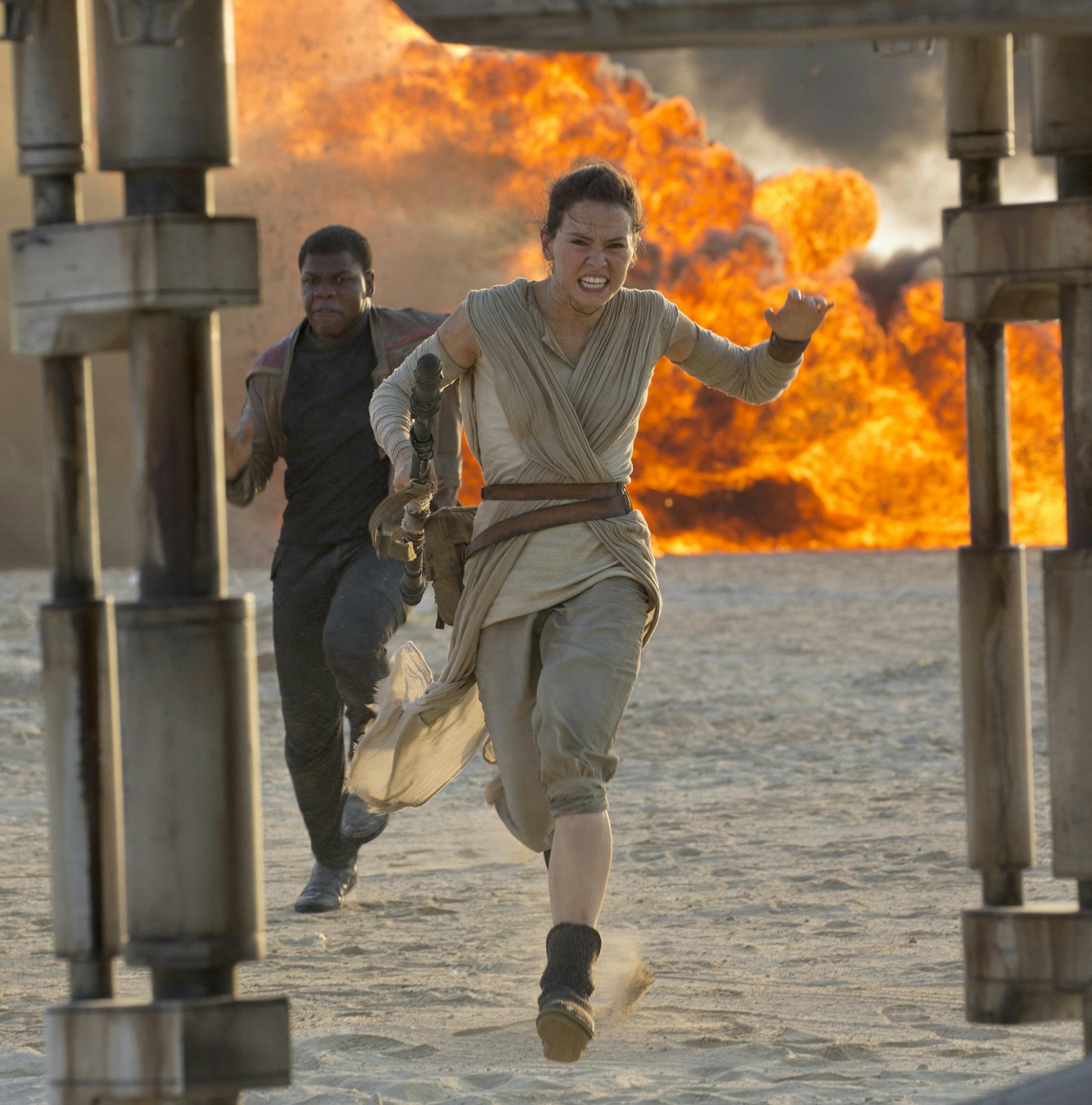 This photo provided by Disney/Lucasfilm shows Daisy Ridley, right, as Rey, and John Boyega as Finn, in a scene from the film, "Star Wars: The Force Awakens," directed by J.J. Abrams. Early screenings of the film begin Thursday night, Dec. 17, 2015. (David James/Disney/Lucasfilm via AP)