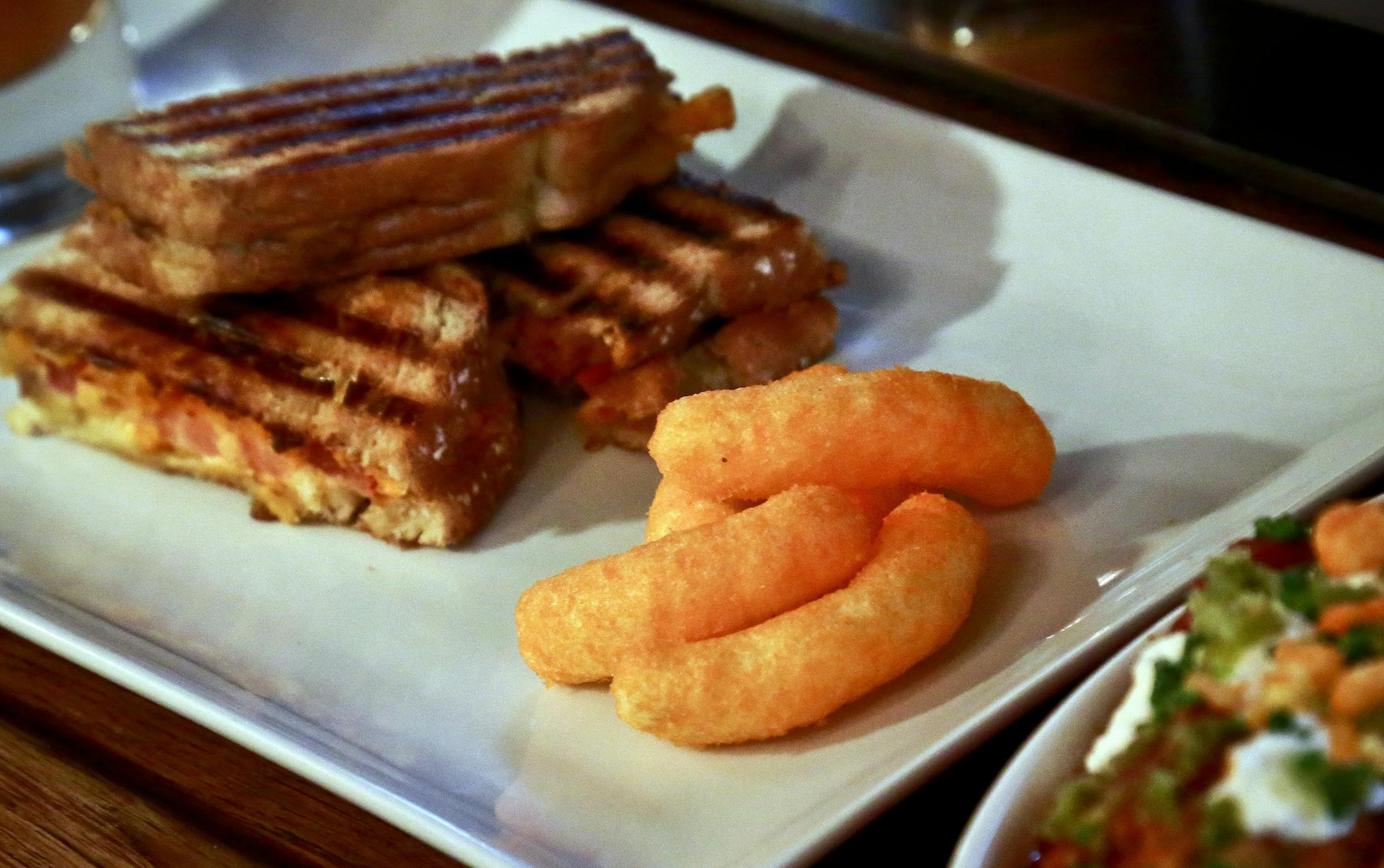 A grill cheese made with Cheetos is shown during a press preview for a three-day pop-up restaurant featuring an all-Cheetos menu, Tuesday Aug. 15, 2017, in New York. Celebrity chef Anne Burrell has been given the unenviable task of creating an entire menu for a pop-up restaurant based on Cheetos. (AP Photo/Bebeto Matthews)