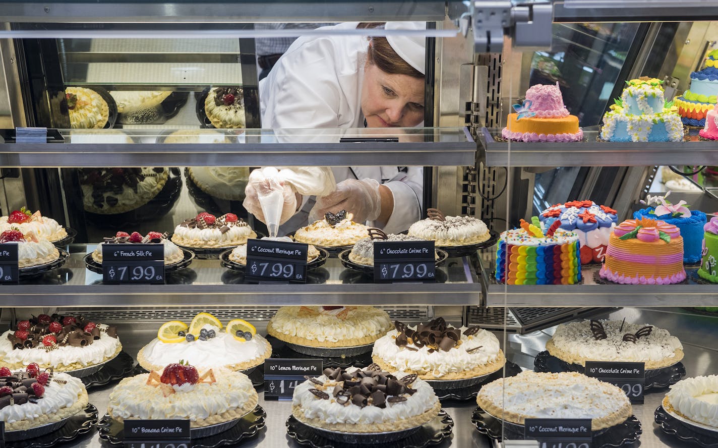 Julie Labens, of Limestone Canyon Marketing, puts the finishing touches on one of the pies in the sweet shop's display. ] Isaac Hale &#xef; isaac.hale@startribune.com A new Hy-Vee supermarket is set to open at 16150 Pilot Knob Rd. in Lakeville, MN, tomorrow. The supermarket offers several new features and improvements such as a clothing department, Mexican Cucina Grill, sweets shop, and expanded grab-and-go meal options.