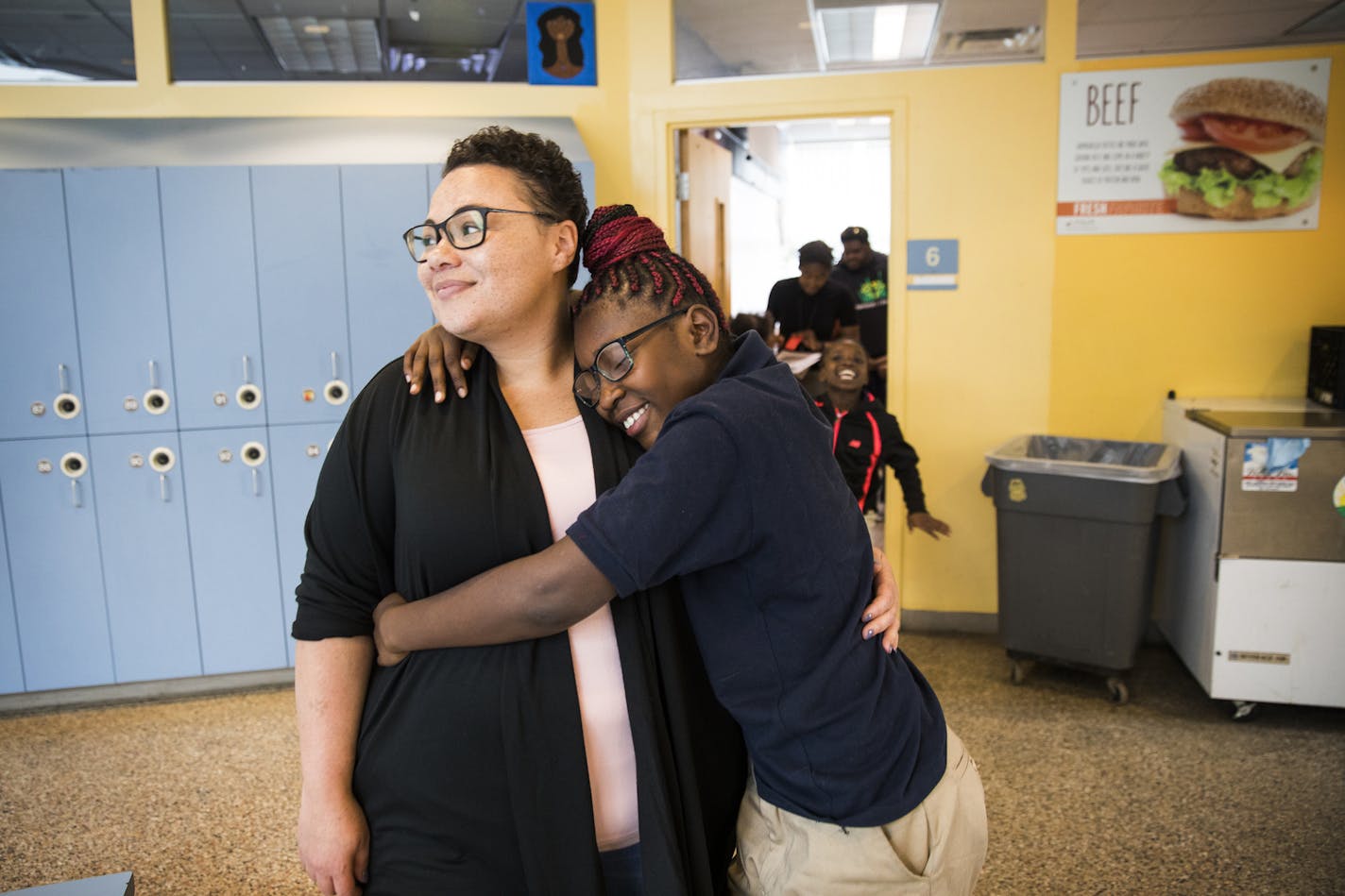 Catrice O'Neal, the director of Out of School Time programs, gets a spontaneous hug from Ebonie Kennedy, 10.