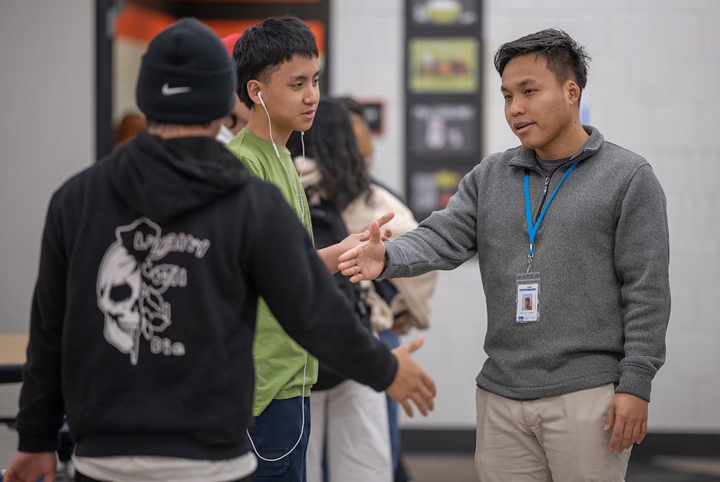 Say Klo Wah, a youth case manager for the Karen Organization of Minnesota, checks in with Karen students at Humboldt High School on March 27.
