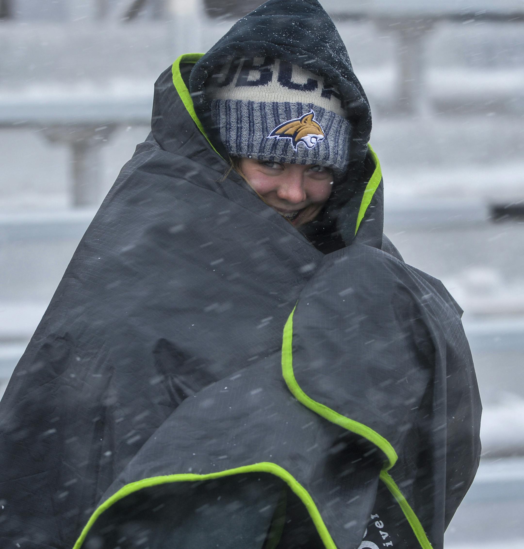 Fans brace against the wind and snow at a football game between Centerville High School and Belt High School, Saturday, Sept. 28, 2019, in Centerville, Mont. Strong winds and heavy snow caused power outages and temporary road closures in northwestern Montana as a wintry storm threatened to drop several feet of snow in some areas of the northern Rocky Mountains. (Rion Sanders/The Great Falls Tribune via AP)