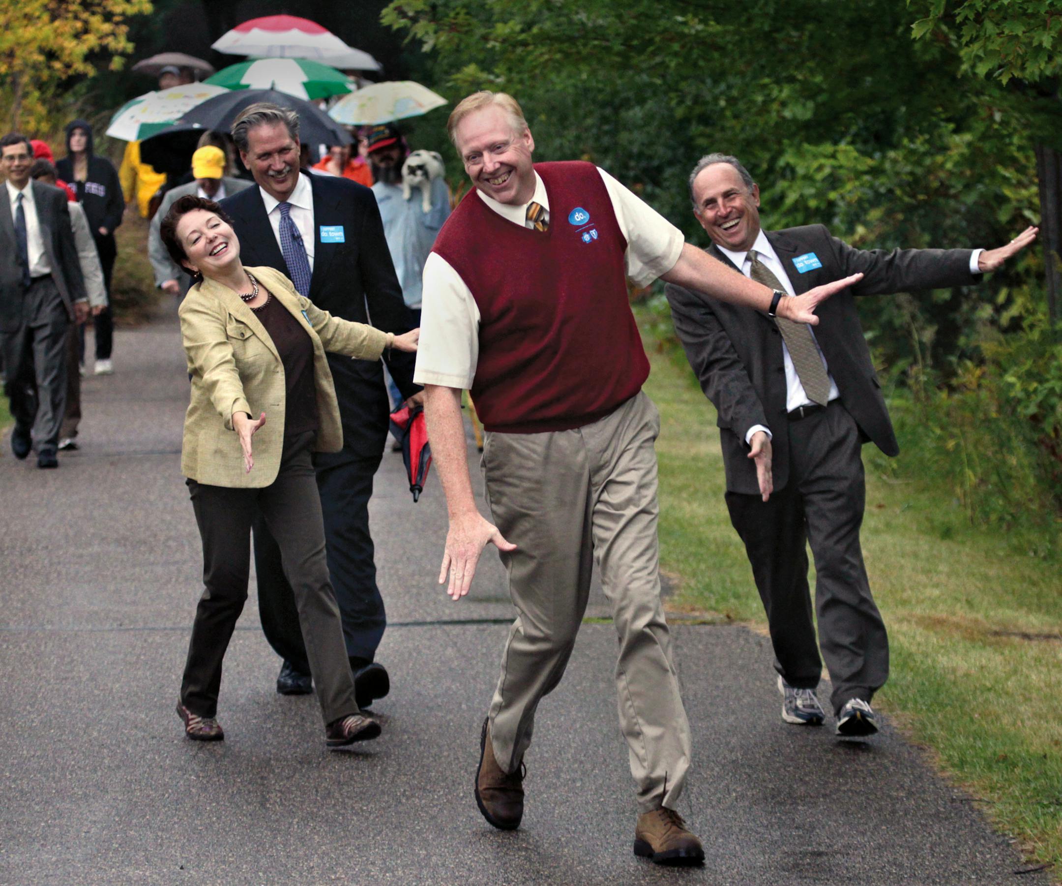 Actor, Dexter Warren, The dancer in a national commercial to promote good health, led, Mayor Debbie Goettel, Richfield, Mayor, Mayor Jim Hovland of Edina, Gene Winstead, Bloomington, with Dr. Marc Manley (way back on left)‚Äî*chief prevention officer of the Blue Cross Blue Shield of Minnesota's on the "do Groove" walk to kick-off their new pilot program that promotes healthy living and eating habits in the respective cities. The walk took place on the walkways around Bloomington