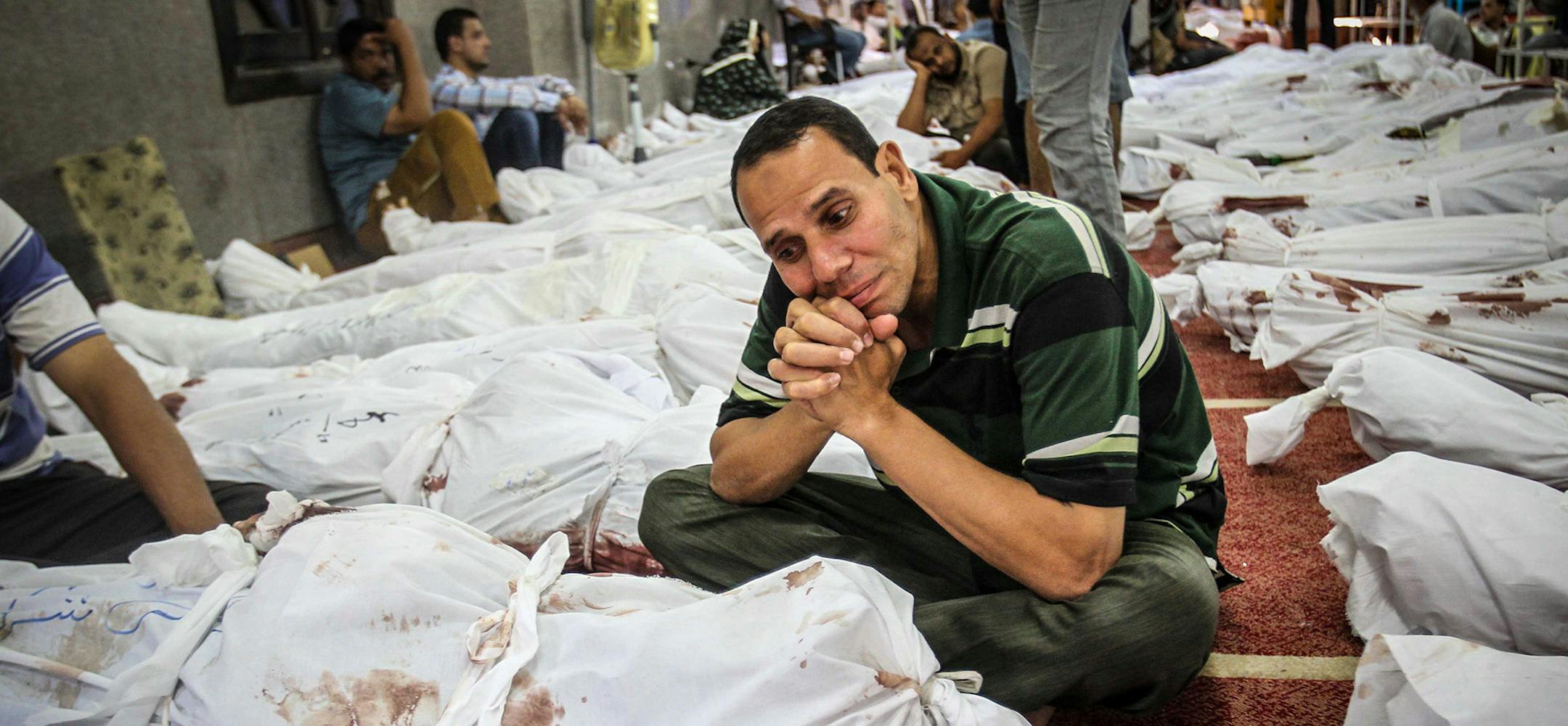 An Egyptian man sits next to the body of a dead relative in Al-Eman mosque, where 361 protester's bodies lay in lines, in Cairo's Nasr City, Thursday, August 15, 2013, the day after security forces broke up Muslim Brotherhood protest camps, leaving hundreds dead. Brotherhood members had been protesting for weeks about the army's overthrow of President Morsi in July. The government says 525 people were killed, but scores of bodies have not been registered. Supporters of President Morsi say more t