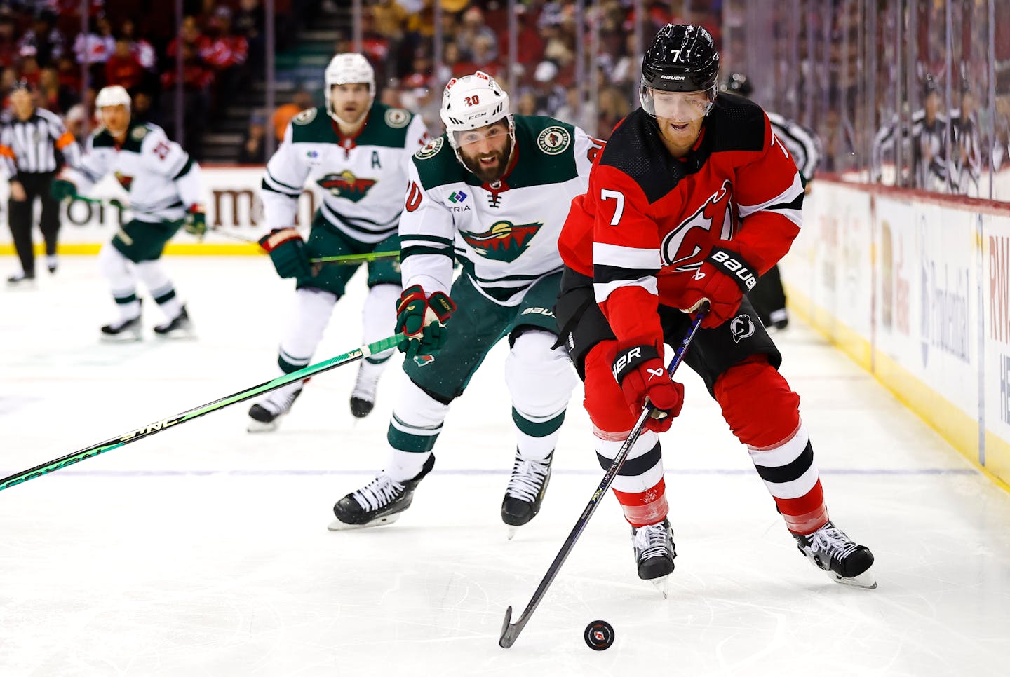 New Jersey Devils defenseman Dougie Hamilton (7) skates with the puck against Minnesota Wild left wing Pat Maroon (20) during the first period of an NHL hockey game, Sunday, Oct. 29, 2023, in Newark, N.J. (AP Photo/Noah K. Murray)