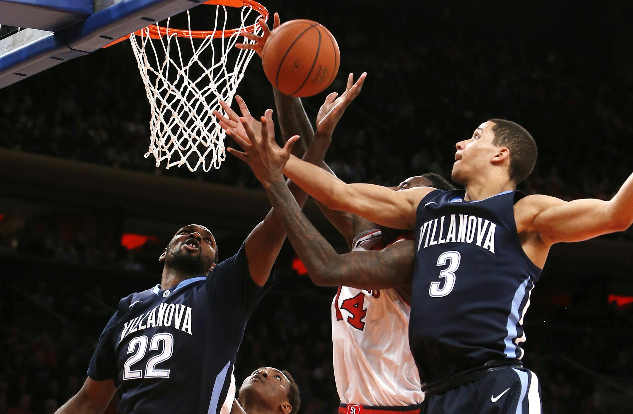 Villanova's JayVaughn Pinkston (22) and Josh Hart (3) go up for a rebound against St. John's JaKarr Sampson (14) during the second half of an NCAA college basketball game Saturday, Jan. 11, 2014, in New York. Villanova won 74-67. (AP Photo/Jason DeCrow)