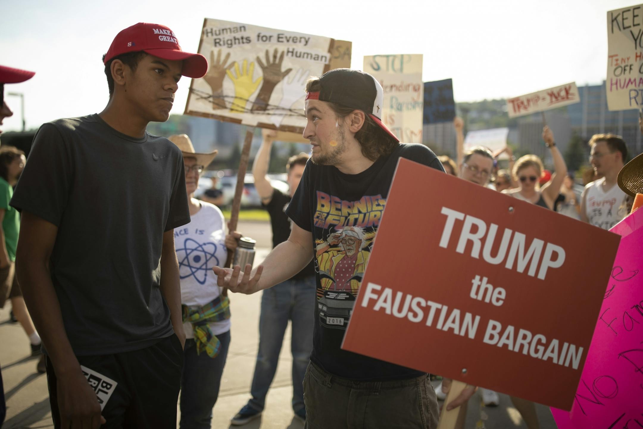A man from Fridley named Dominic, left, who declined to give his last name, engaged in a dialogue with Gary Nieman of Duluth outside Amsoil Arena.