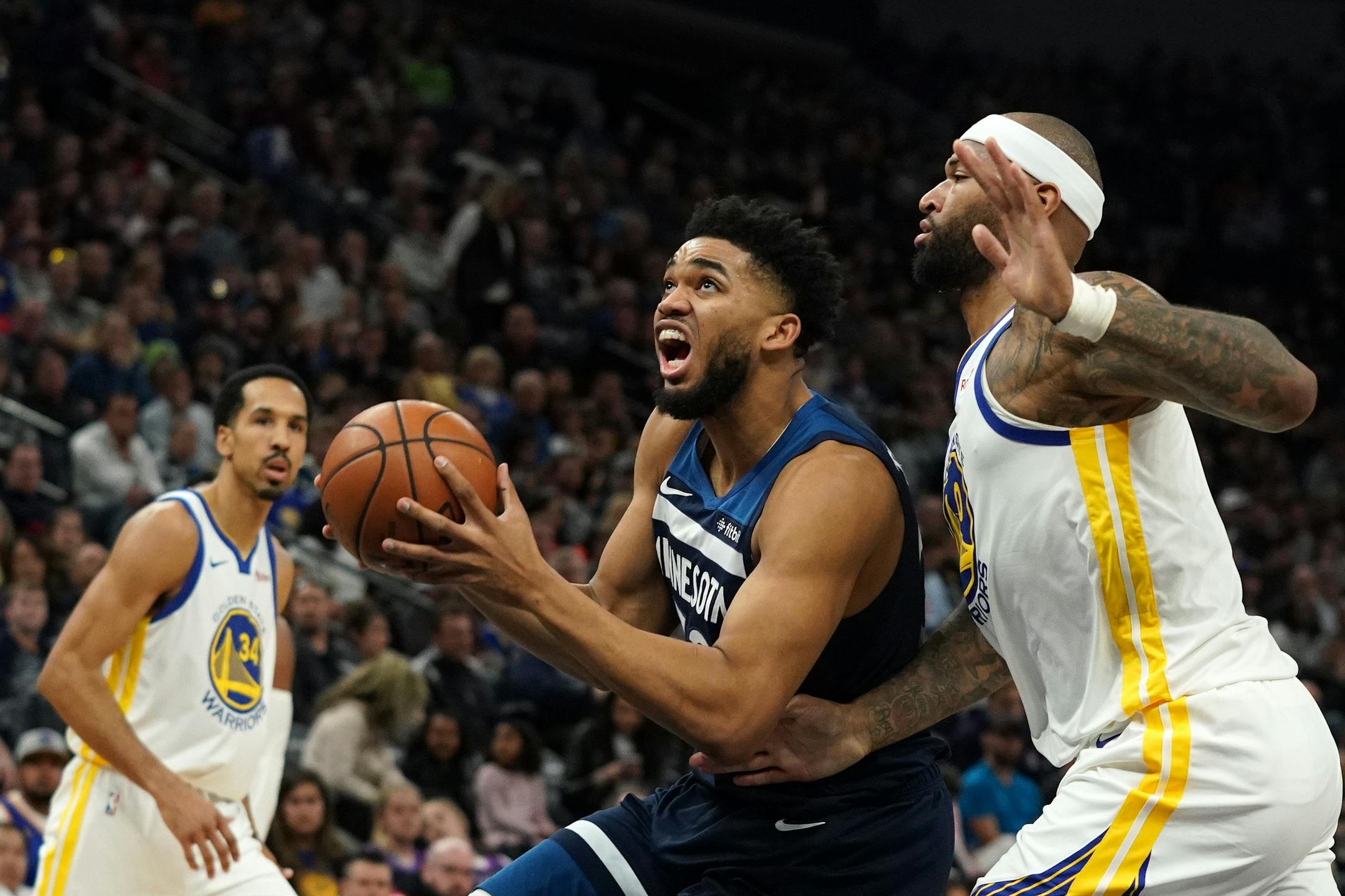 Timberwolves center Karl-Anthony Towns drove to the basket as Warriors center DeMarcus Cousins raced to defend