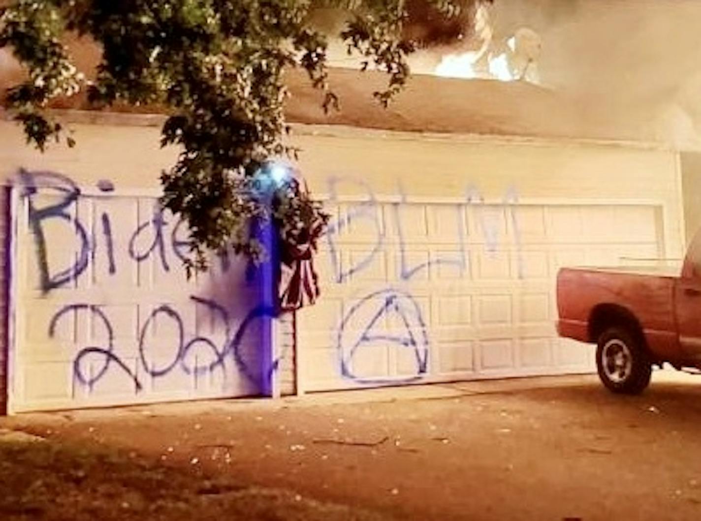 Graffiti marked the doors of a garage that burned to the ground in a suspected case of arson at the home of Brooklyn Center Trump supporters Dennis and Deana Molla.