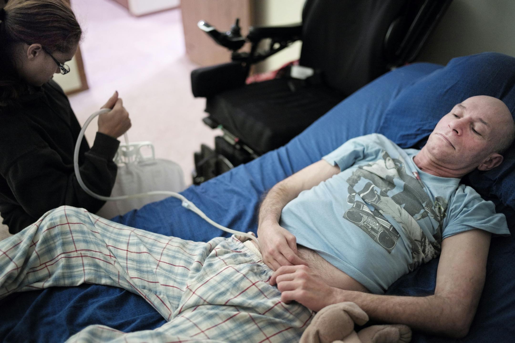 Jerry Parsons gets help from 26-year old caregiver, Shante Wilson, a former Crystal Care employee who helps the multiple sclerosis patient stretch out, empty his catheter, and move him to his wheelchair.