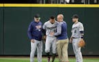 Minnesota Twins center fielder Byron Buxton, second from left, is attended to by head trainer Tony Leo, second from right, after he crashed into the w