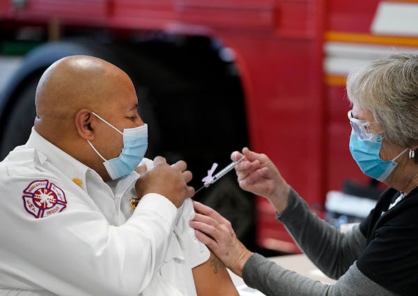Minneapolis Fire Chief Bryan Tyner received his first COVID-19 vaccination from nurse Mary Greer of Hennepin Health in 2020.