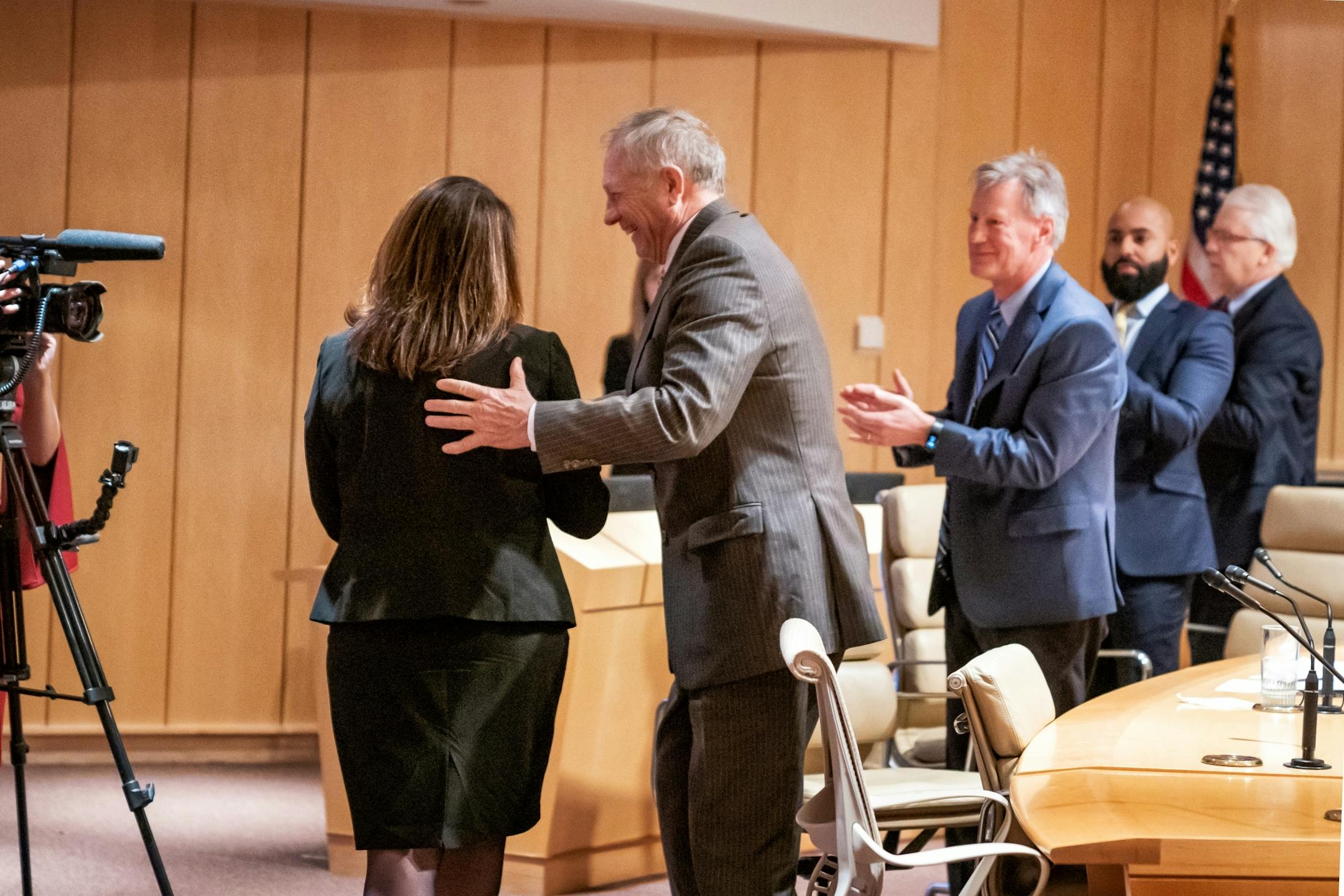 Joan Gabel rose to greet members of the Board of Regents after they unanimously voted to hire her as the university's first female president. First in the group was Steve Sviggum.