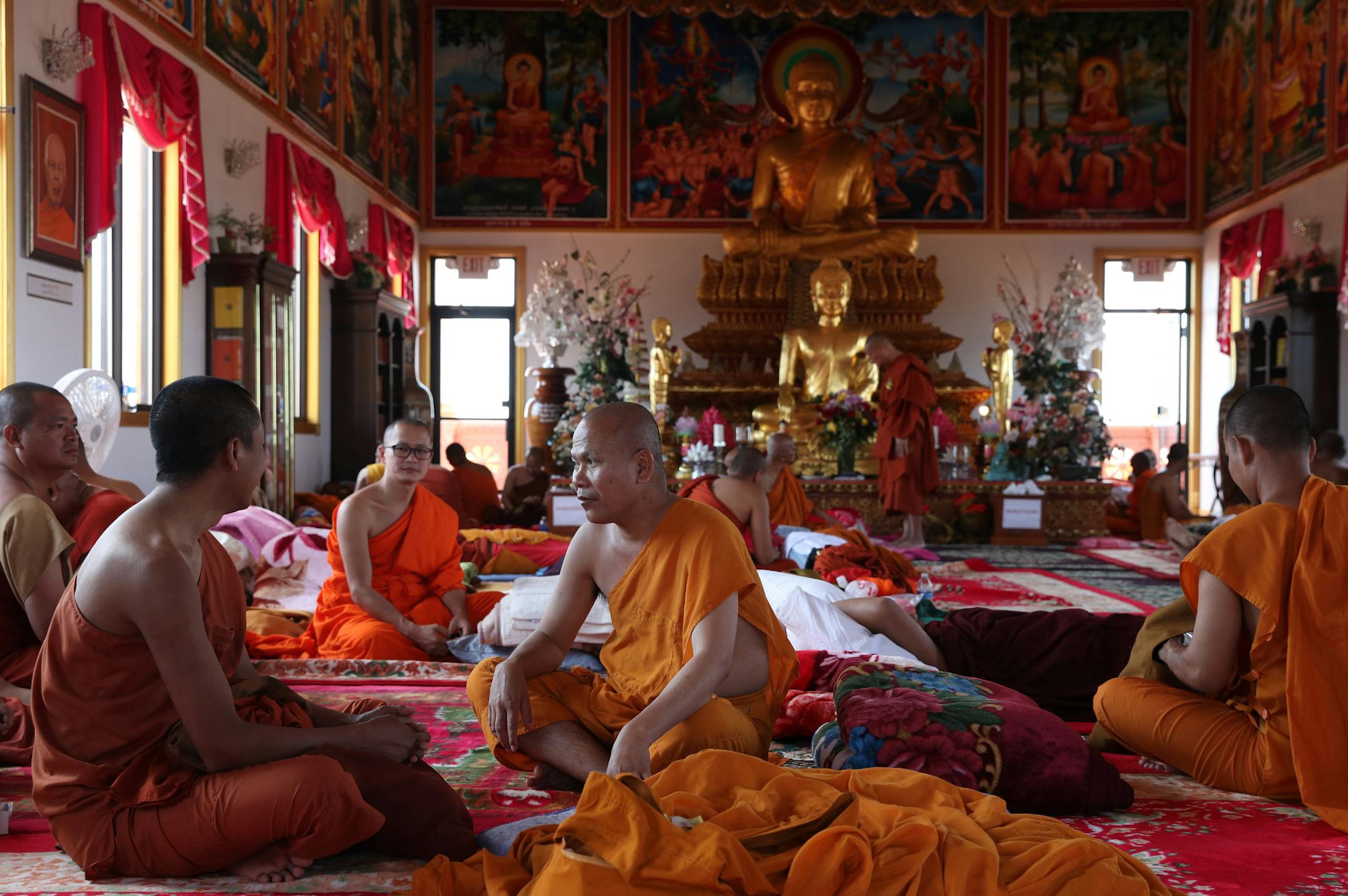 Monks sat with one another as they took a break from the heat of the day at the Watt Munisotaram Saturday. ] ANTHONY SOUFFLE ï anthony.souffle@startribune.com Monks and members of the public celebrated the Inauguration of the Mucalinda Pond at the Watt Munisotaram, a local Buddhist temple, Saturday Aug. 12, 2017 in Hampton, Minn. The three-day celebration involves the sanctification of the Buddha statue in the Reflection pool.