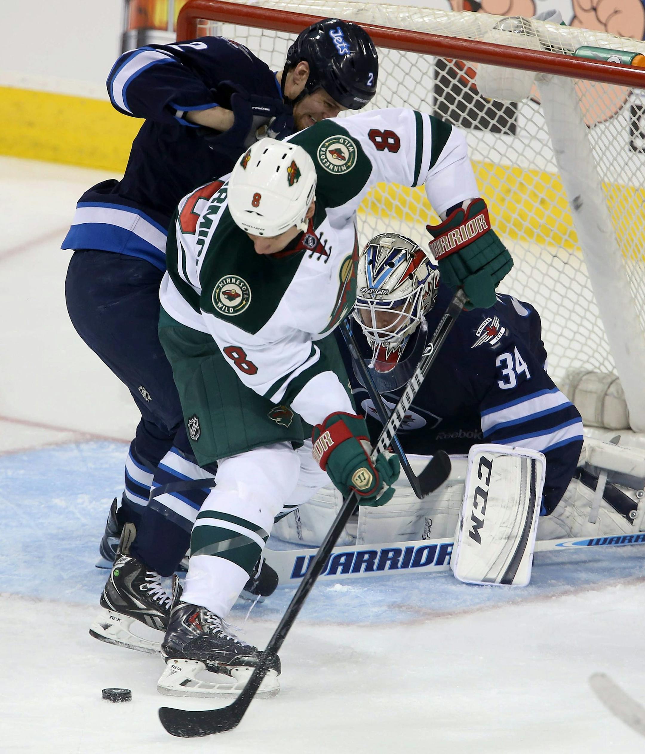 Winnipeg Jets' Adam Pardy (2) battles with Minnesota Wild's Cody McCormick (8) in front of Jets' goaltender Michael Hutchinson (34) during first period NHL hockey action in Winnipeg, Manitoba, Monday, April 7, 2014. (AP Photo/The Canadian Press, Trevor Hagan)