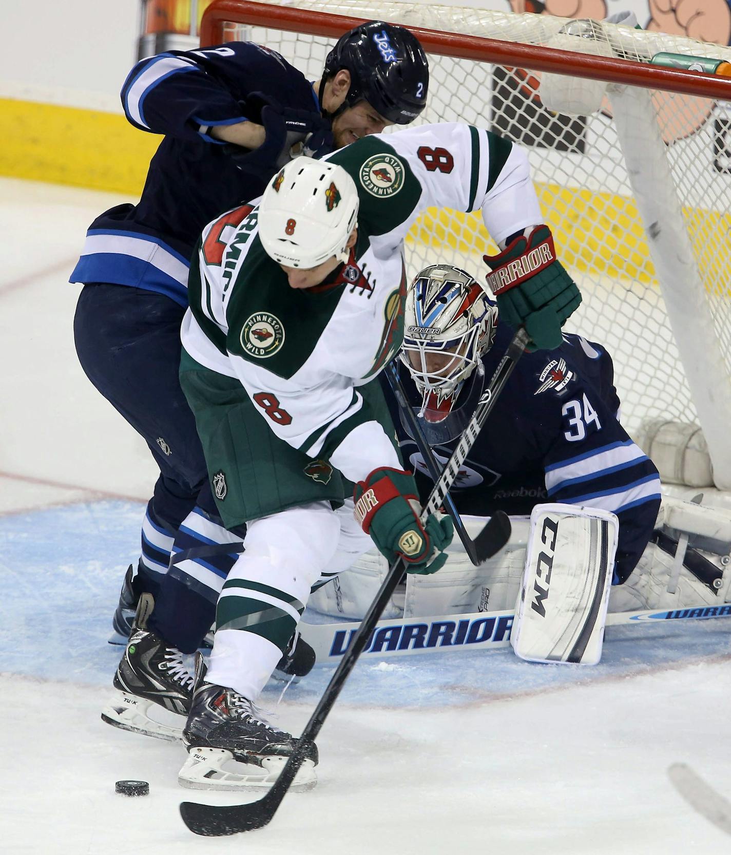 Winnipeg Jets' Adam Pardy (2) battles with Minnesota Wild's Cody McCormick (8) in front of Jets' goaltender Michael Hutchinson (34) during first period NHL hockey action in Winnipeg, Manitoba, Monday, April 7, 2014. (AP Photo/The Canadian Press, Trevor Hagan)