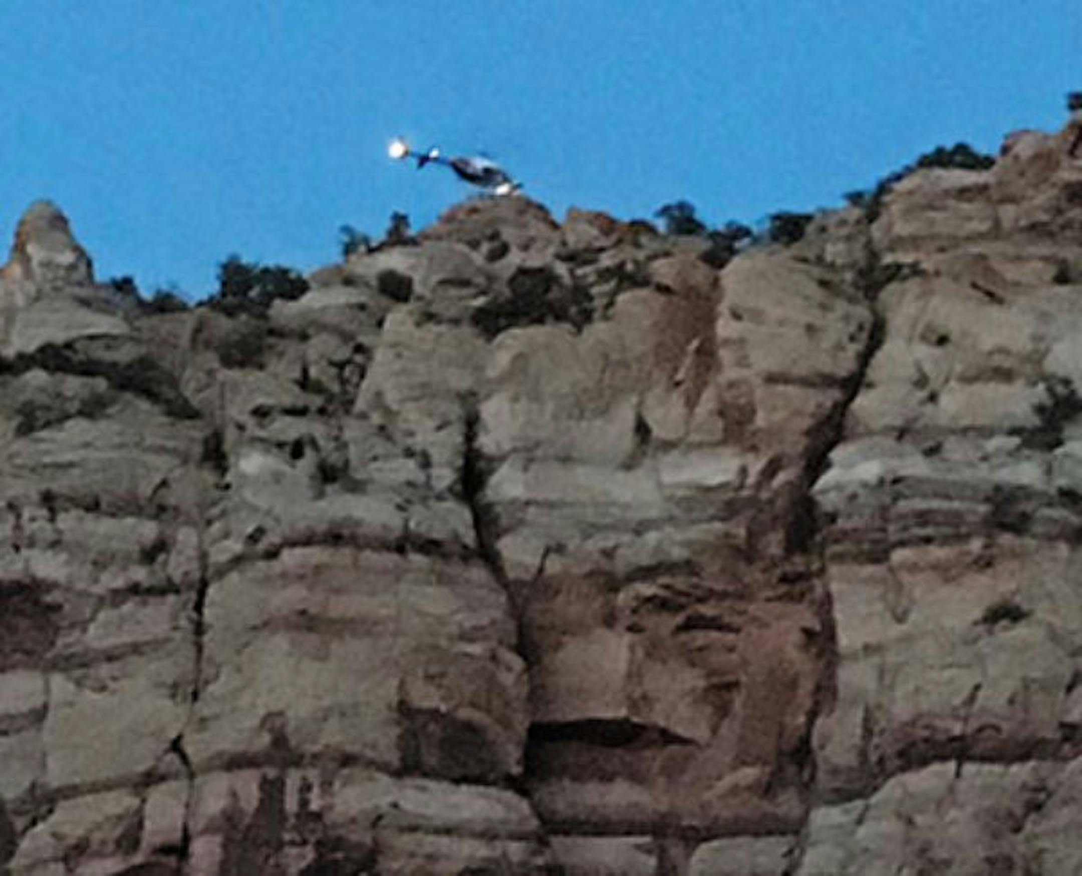 A helicopter pilot hovers his aircraft above an 800-foot cliff during the rescue of an injured hiker Saturday.